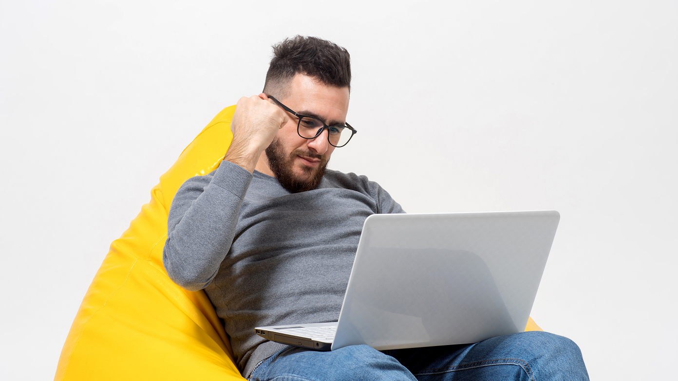 A happy guy in front of a laptop